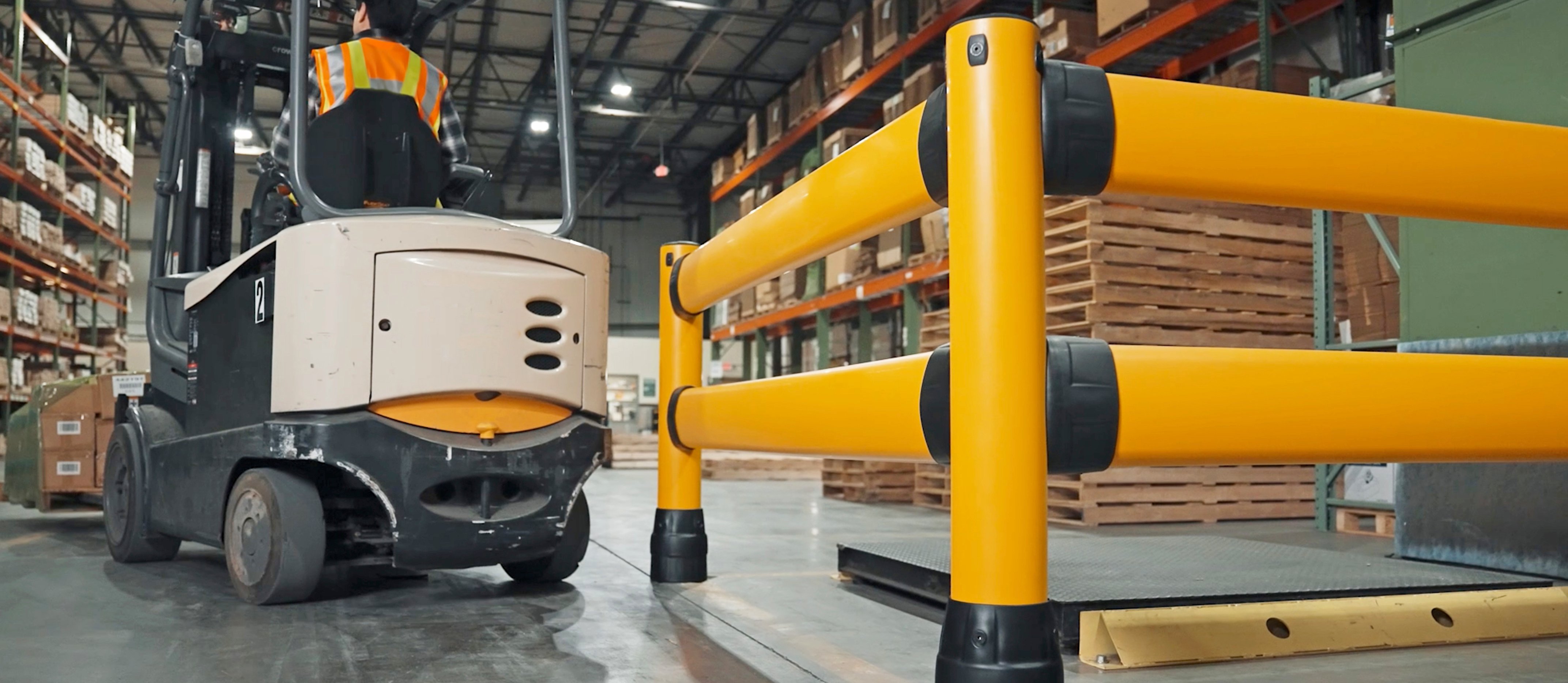 Forklift operating near McCue FLEX+ safety guardrail in warehouse aisle
