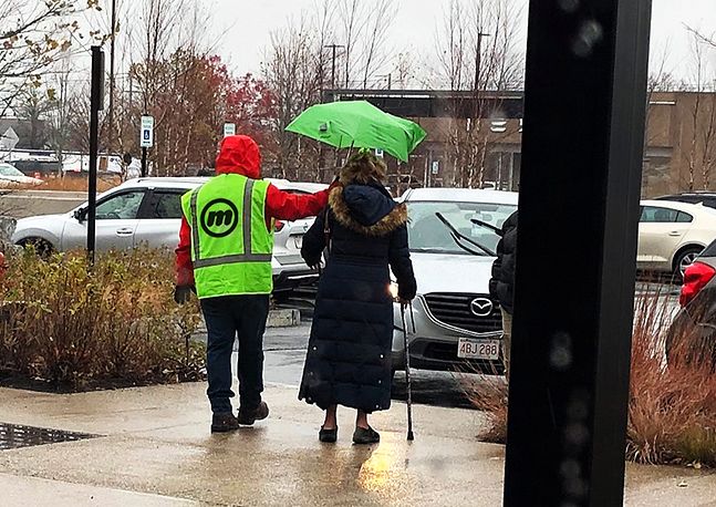 photo of someone holding an umbrella for another person