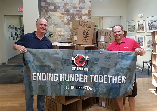 photo of two people holding a banner that says ending hunger together