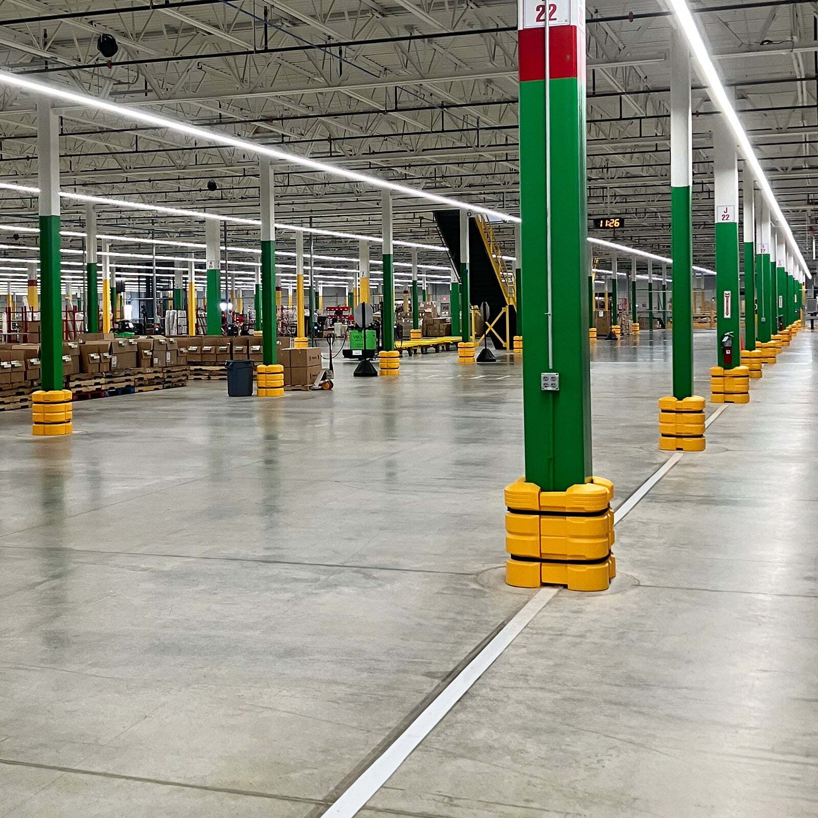 ColumnGuards on green steel columns along a racking aisle in a distribution center.