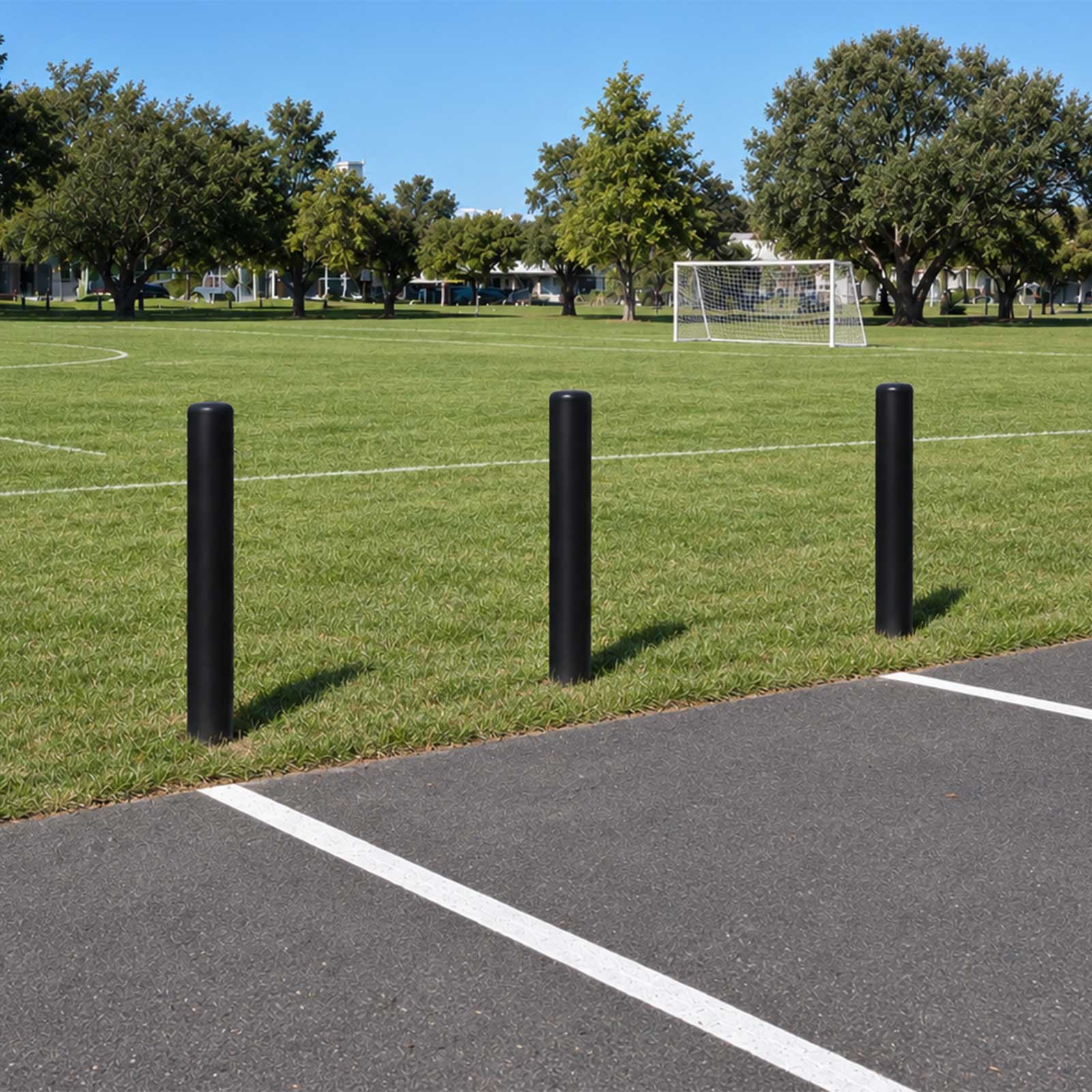 CrashCore Bollard S10 Soil installed in turf between a parking lot and a community soccer field