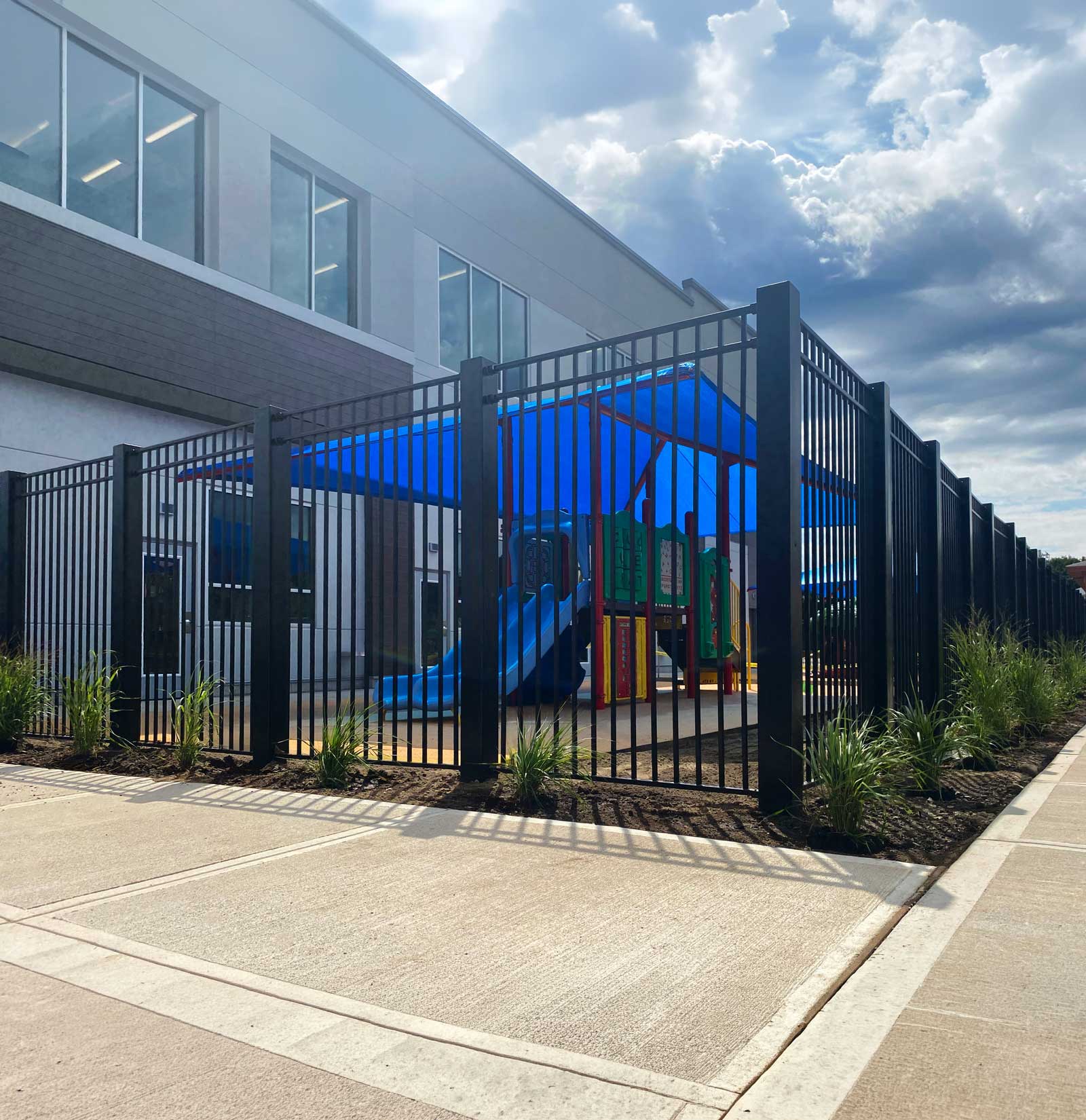 CrashCore Ornamental Fence S10 enclosing a childcare playground with a shaded play structure