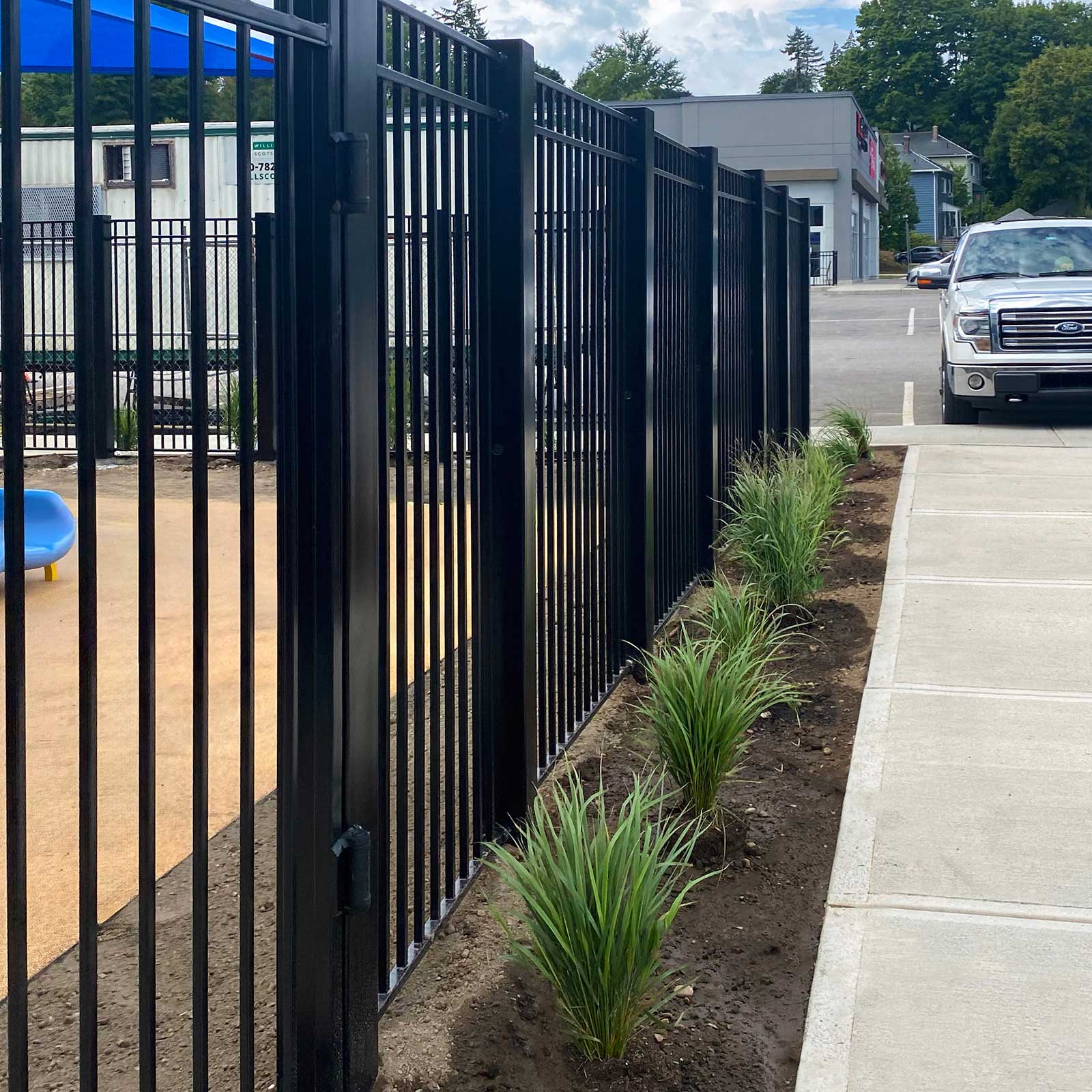 CrashCore Ornamental Fence S10 with a pedestrian gate separating a childcare playground from an adjacent parking lot