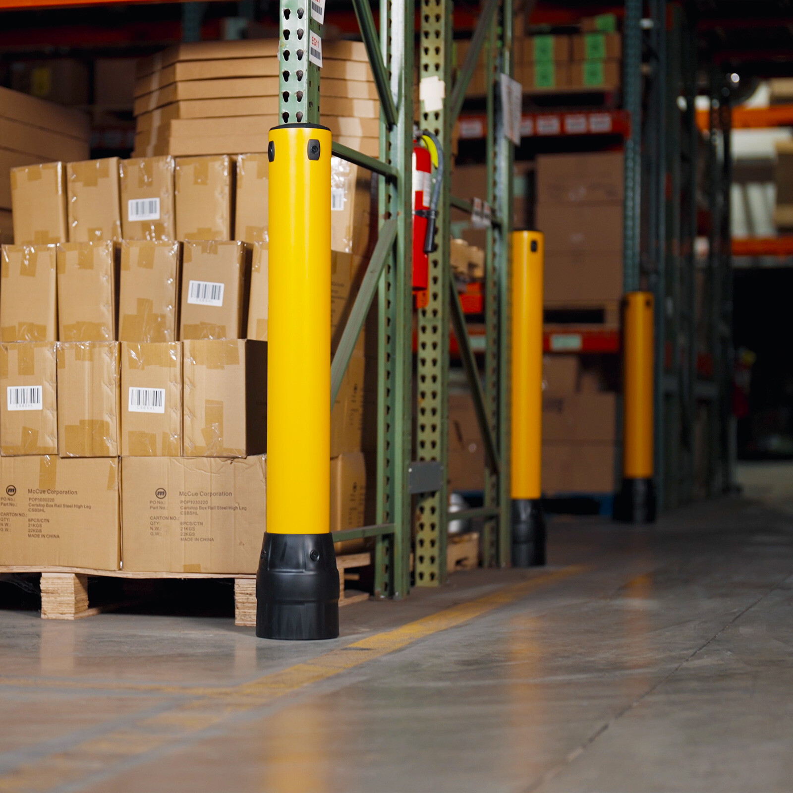 Three FLEX+ Bollards protecting pallet rack ends and corners from forklift impact in a warehouse.
