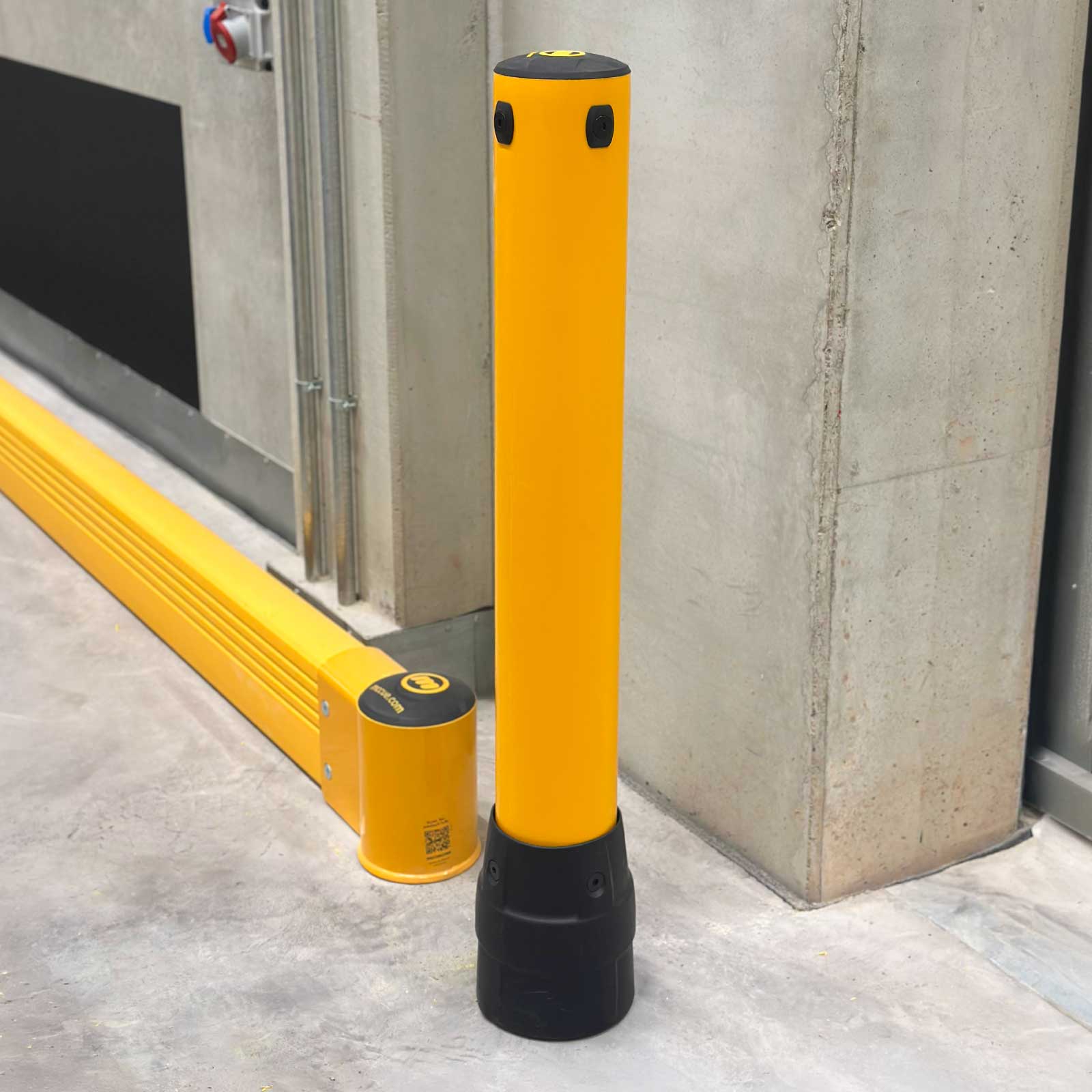 FLEX+ Bollard beside a SafeStop GroundBarrier, shielding a concrete wall corner in a warehouse from forklift impact.
