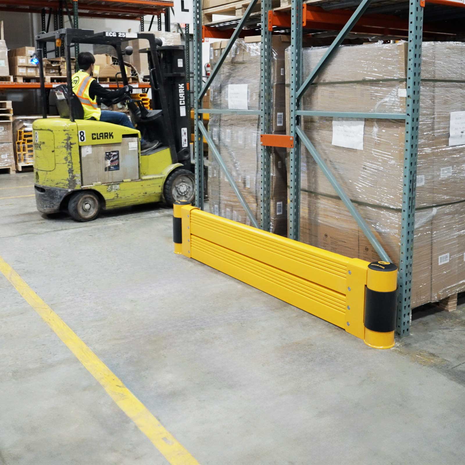 Pallet rack end shielded by a GroundBarrier Double as a forklift passes in a distribution center.