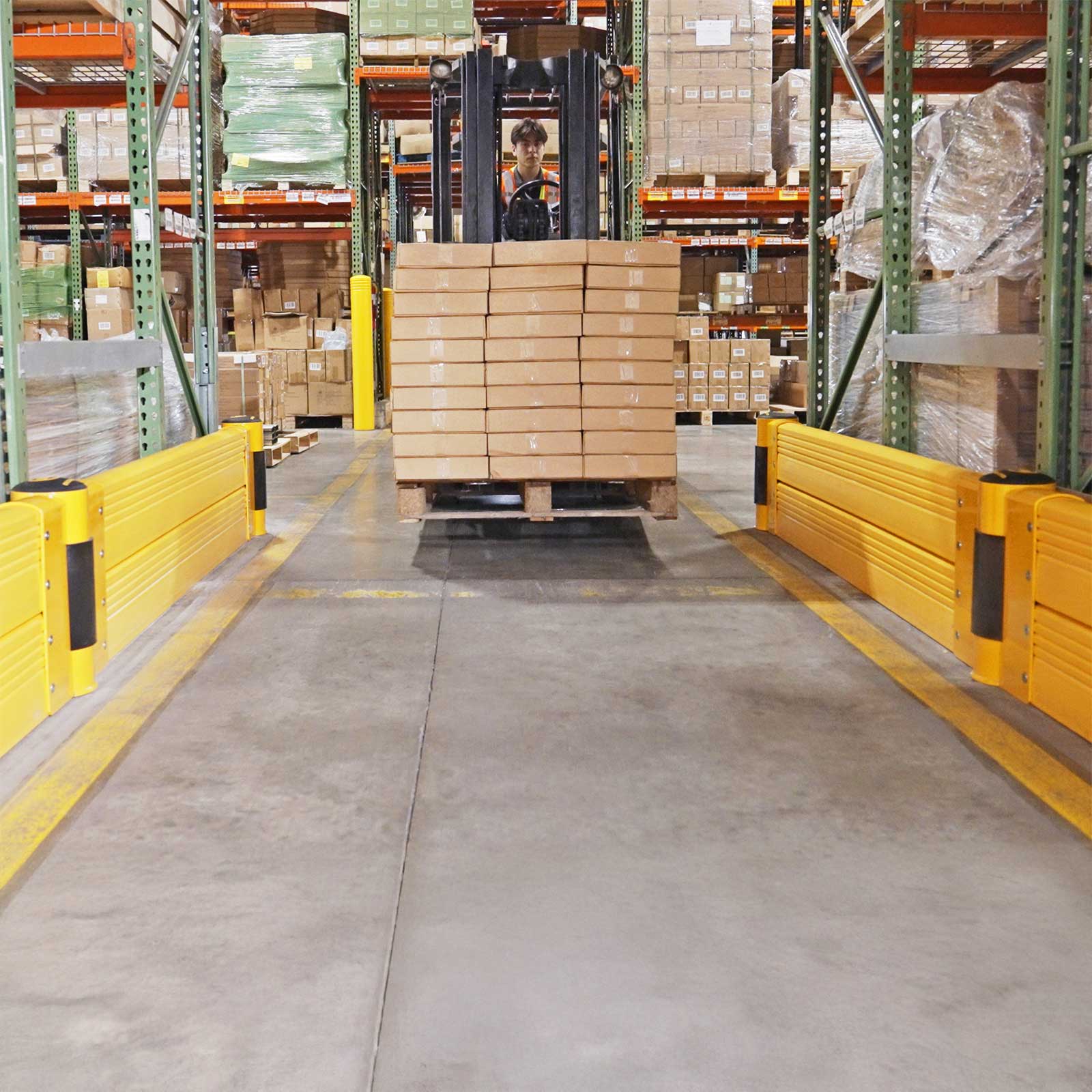 GroundBarrier Double runs lining both sides of a warehouse aisle as a forklift carries a pallet.