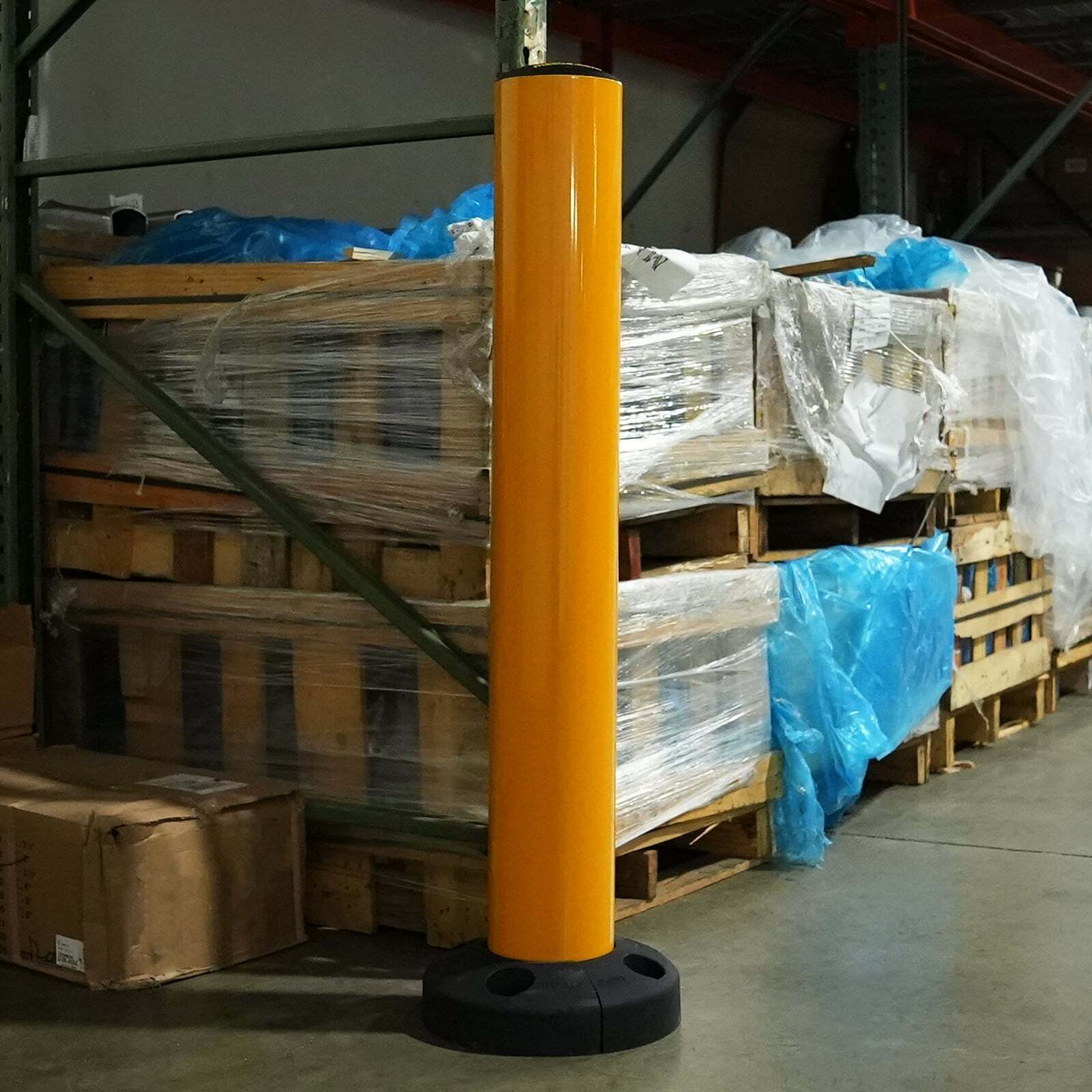 SafeStop Bollard 15 protecting the end of a loaded pallet rack in a warehouse.