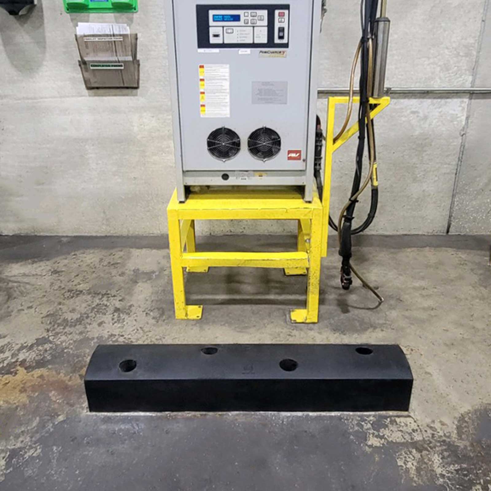 An electrical unit on a yellow steel stand protected from forklift impacts by a SafeStop ForkShield.