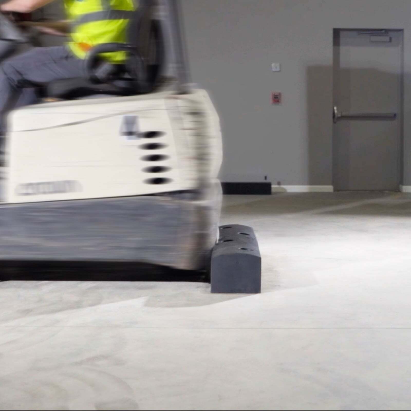 A forklift driving into a SafeStop ForkShield floor-mounted barrier during impact testing.