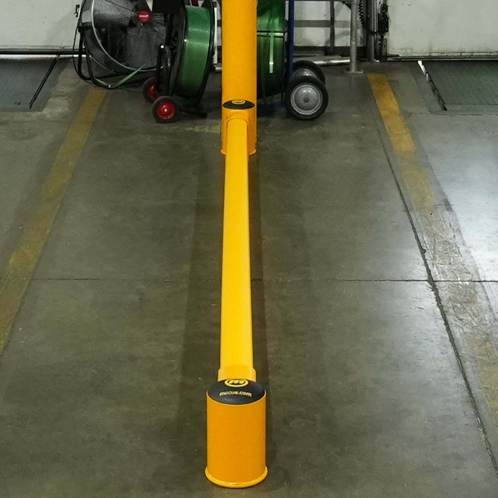 SafeStop GroundBarrier run down the center of a facility floor, dividing two striped lanes.