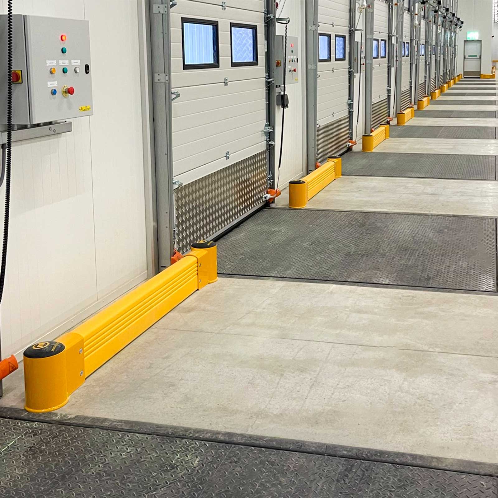 SafeStop GroundBarrier runs protecting the wall between doors along a row of loading docks.