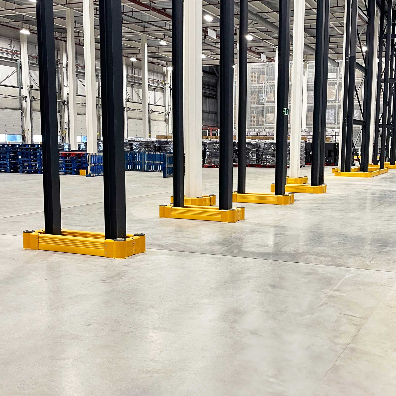 SafeStop GroundBarrier wrapped around the bases of steel columns in a large distribution center.