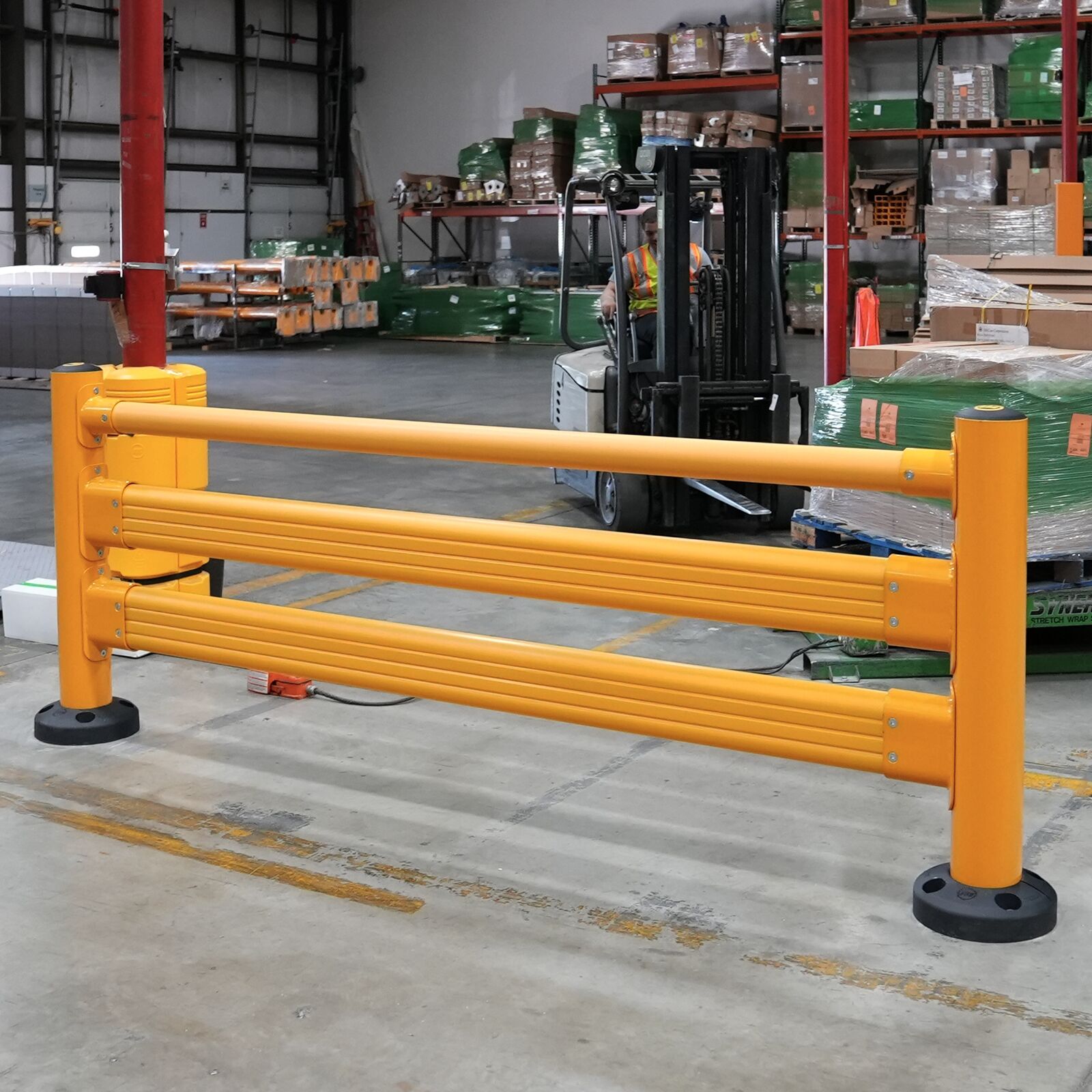 SafeStop Pedestrian GuardRail section in a warehouse aisle, with a forklift and pallet racking behind it.
