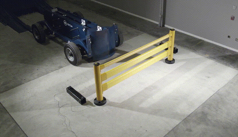 Impact test of SafeStop Pedestrian GuardRail, its rails flexing as a blue McCue test vehicle strikes the section.