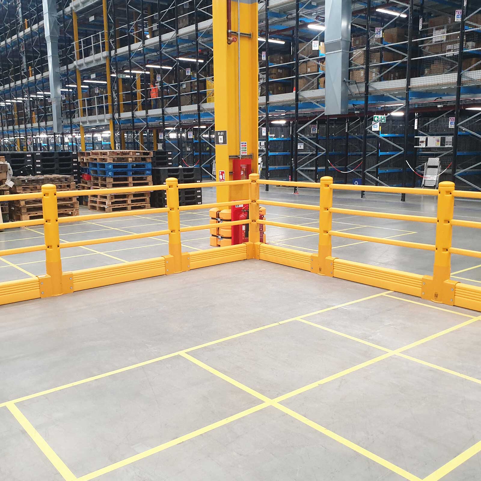 SafeStop Pedestrian with GroundBarrier corner run beside high-bay racking and a yellow-marked floor area in a warehouse.
