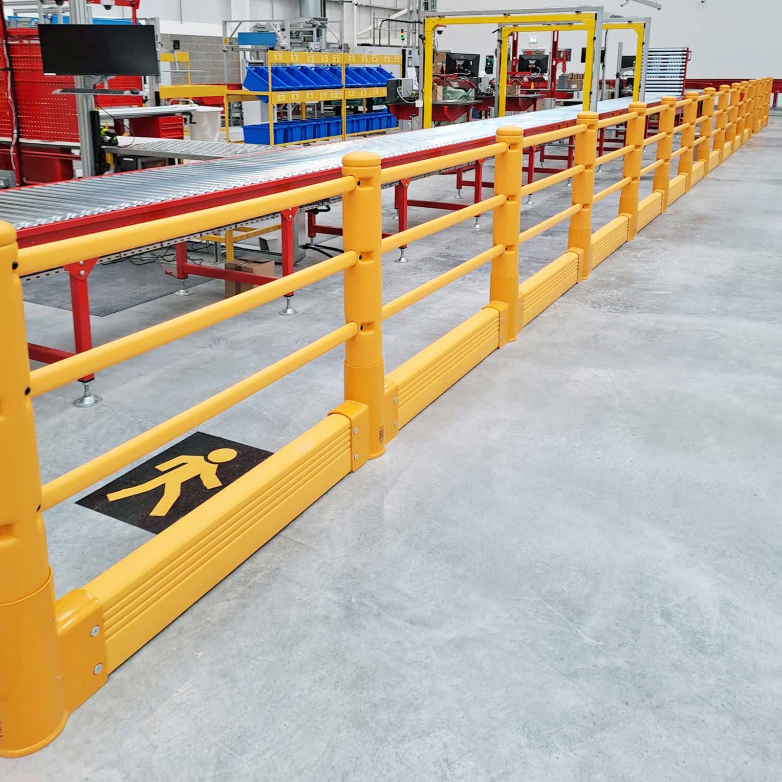 Pedestrian walkway marked with a floor symbol, lined by a SafeStop Pedestrian with GroundBarrier beside a conveyor.