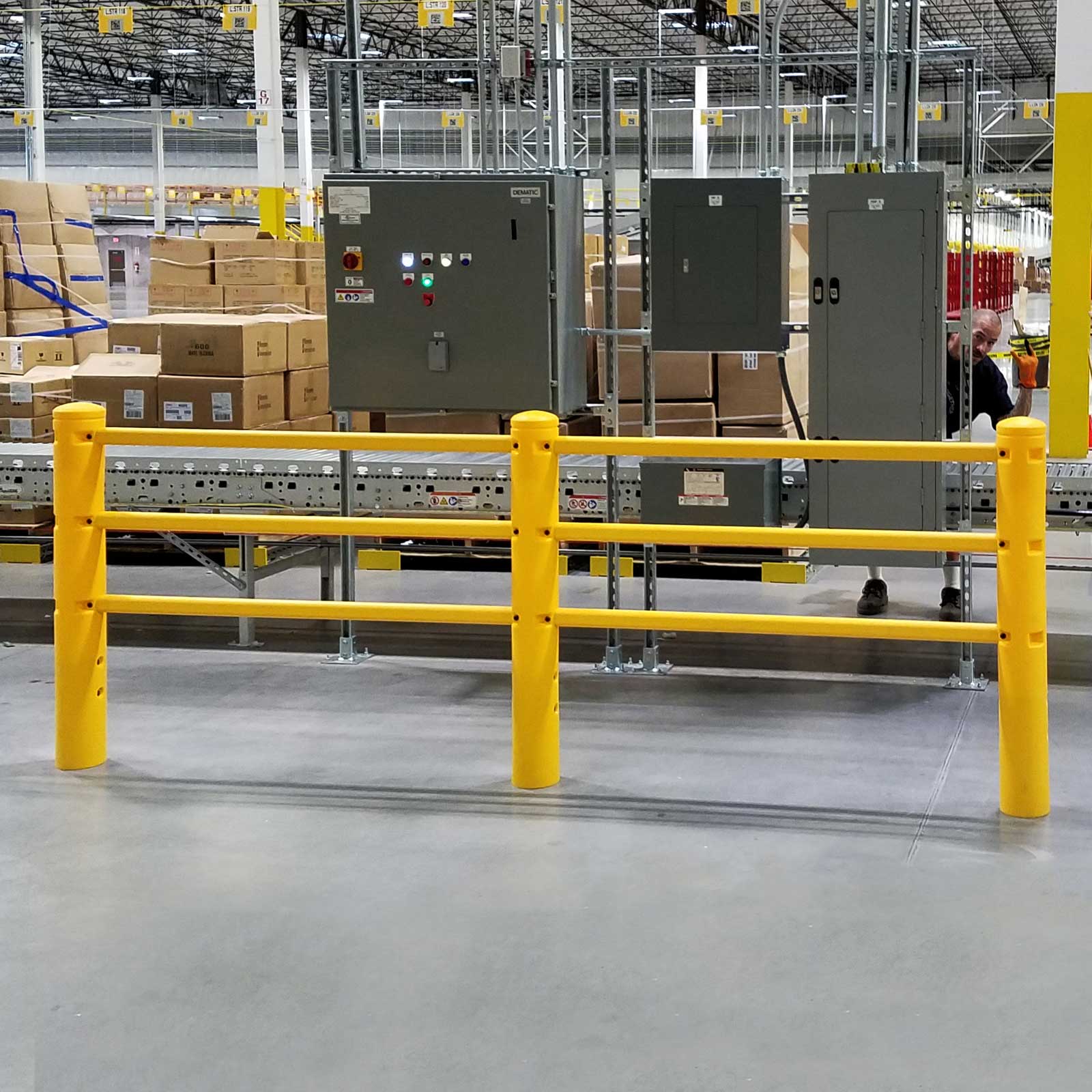SafeStop PedestrianBarrier guarding electrical panels beside a conveyor in a distribution center.