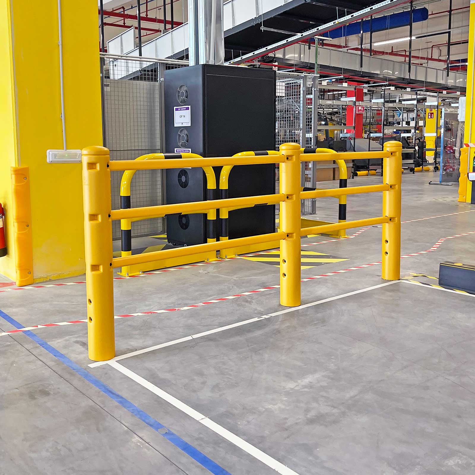 SafeStop PedestrianBarrier run in front of a black equipment cabinet, with blue and white floor lines.