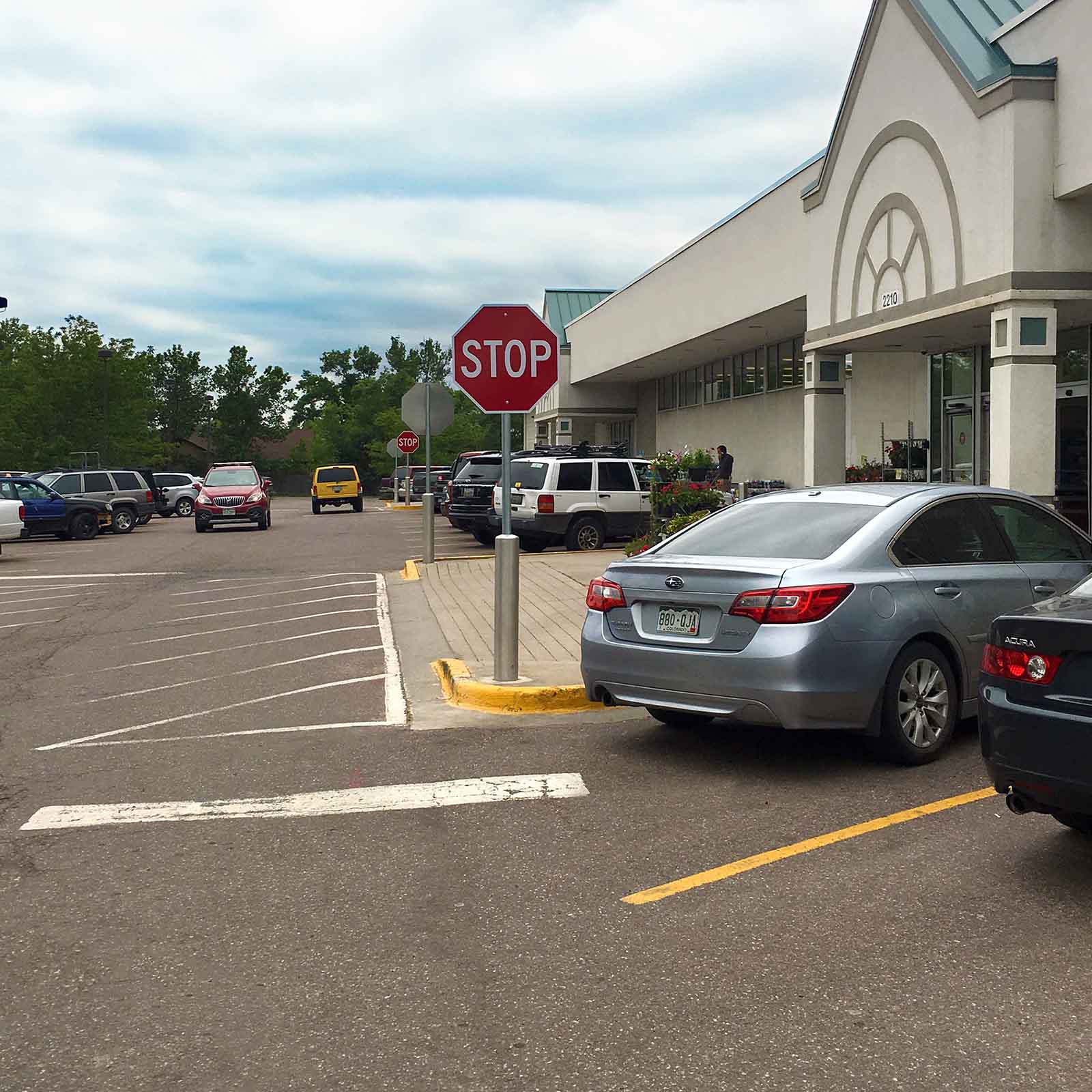 McCue Crash Tested ASTM F3016 CrashCore Bollard with Sign Post in parking lot