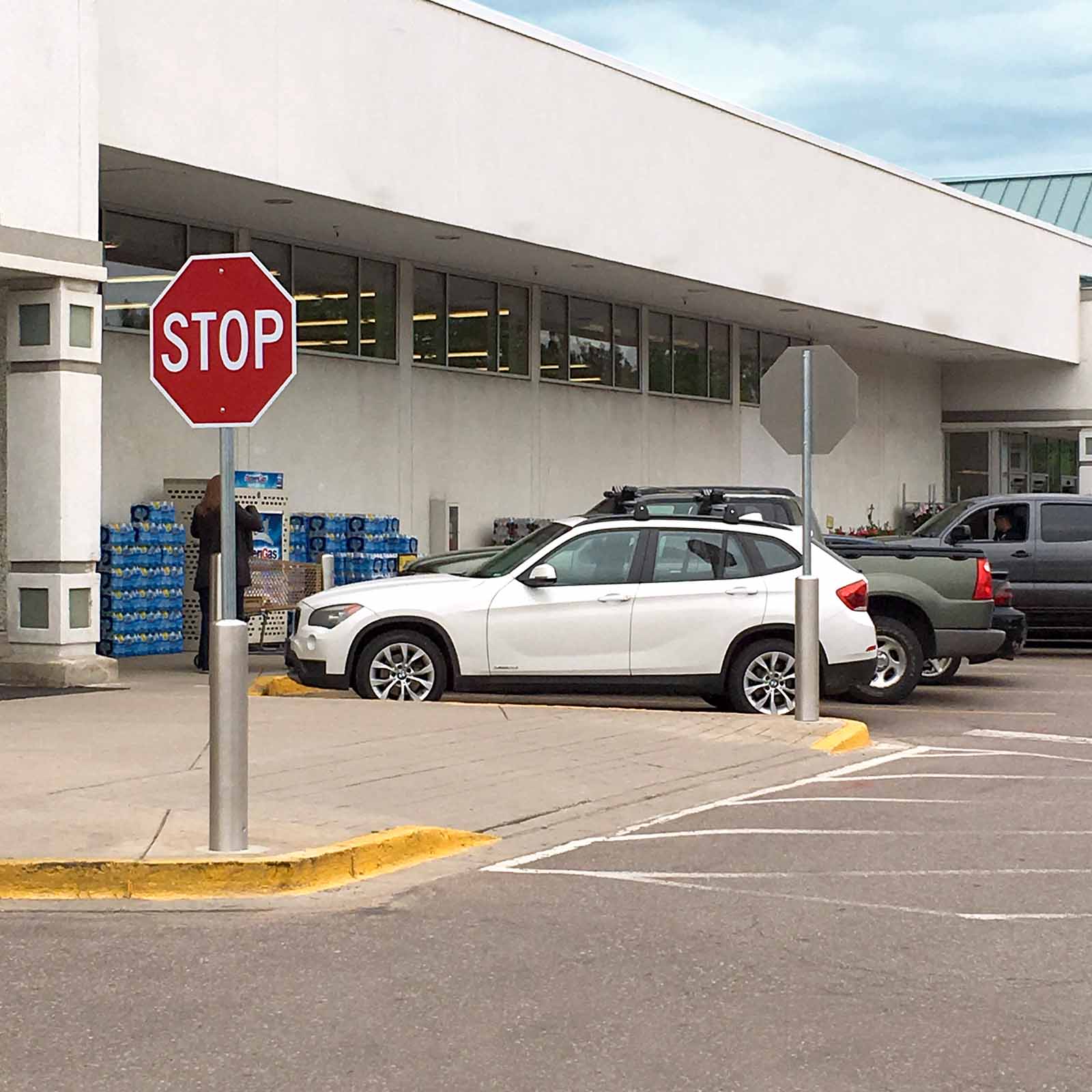 McCue Crash Tested ASTM F3016 CrashCore Bollard with Sign Post in parking lot